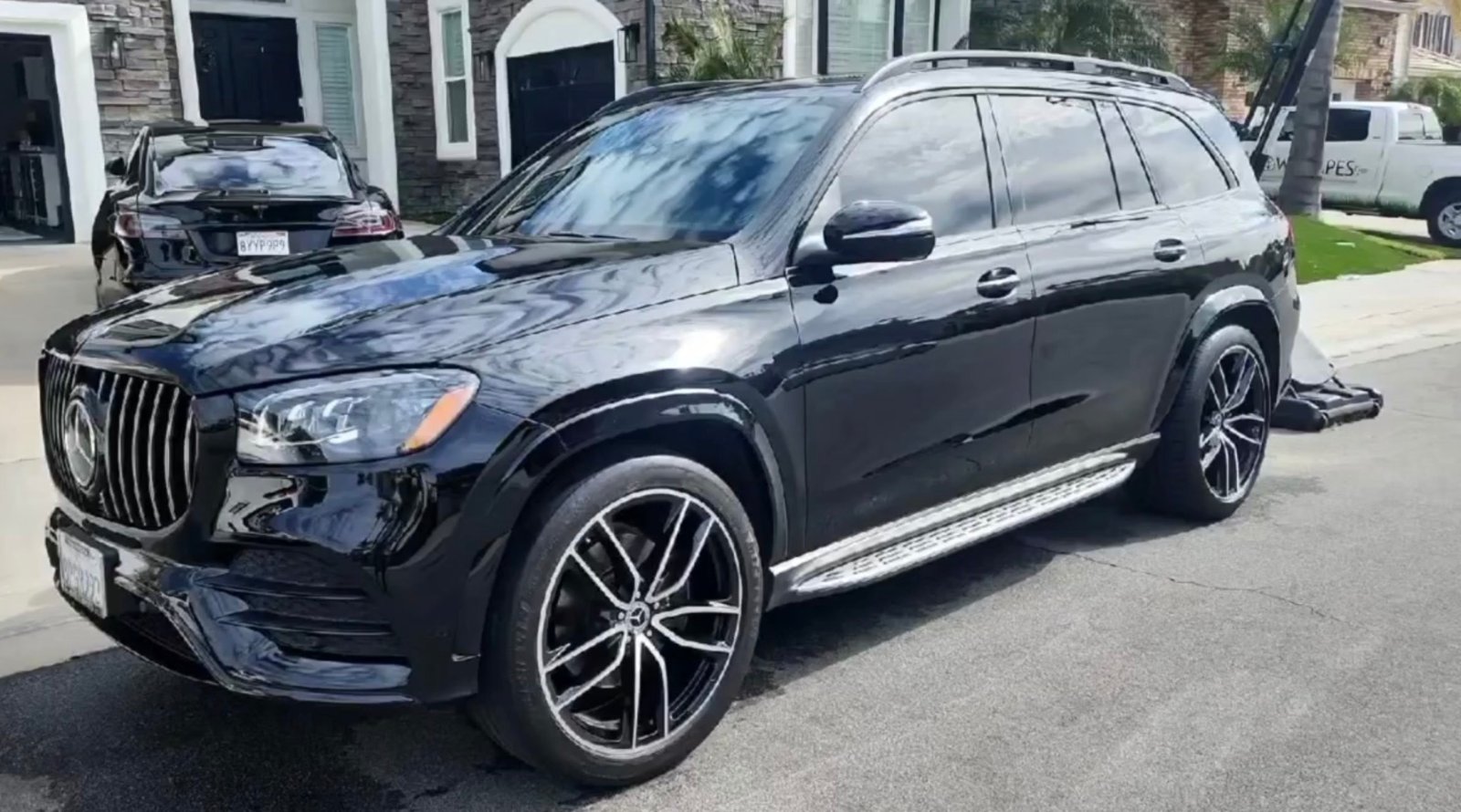 Professional mobile detailer hand washing a car in a driveway